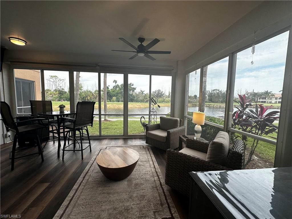 Sunroom / solarium featuring a ceiling fan and a water view