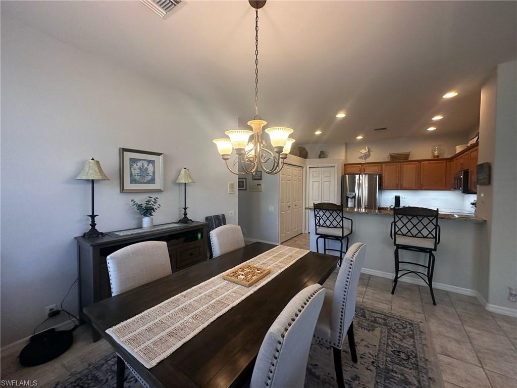 Dining space featuring baseboards, a notable chandelier, visible vents, and recessed lighting
