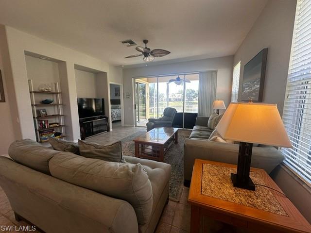 Living area with ceiling fan, visible vents, and plenty of natural light