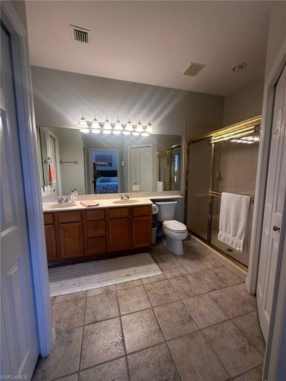 Bathroom featuring a sink, visible vents, and a stall shower