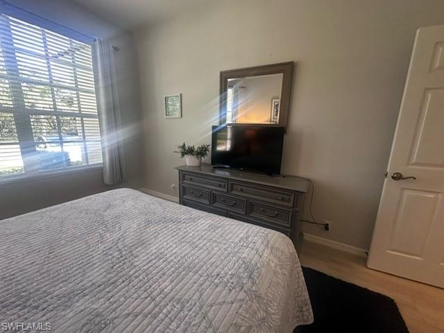 Bedroom with wood finished floors and baseboards