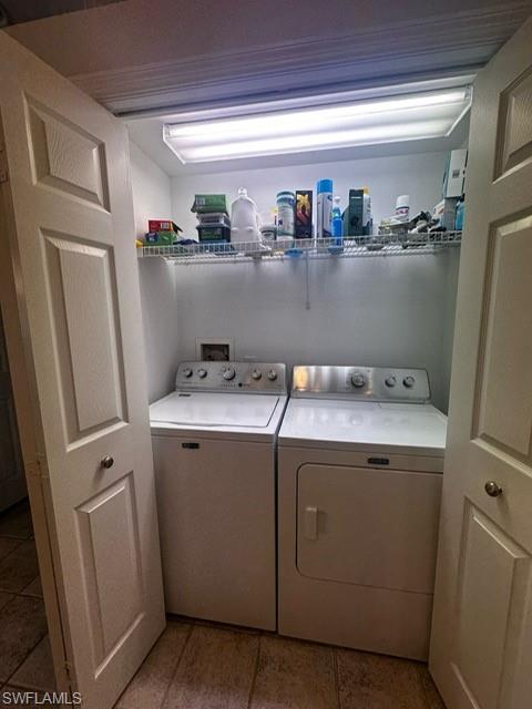 Laundry room with tile patterned floors, washer and dryer, and laundry area
