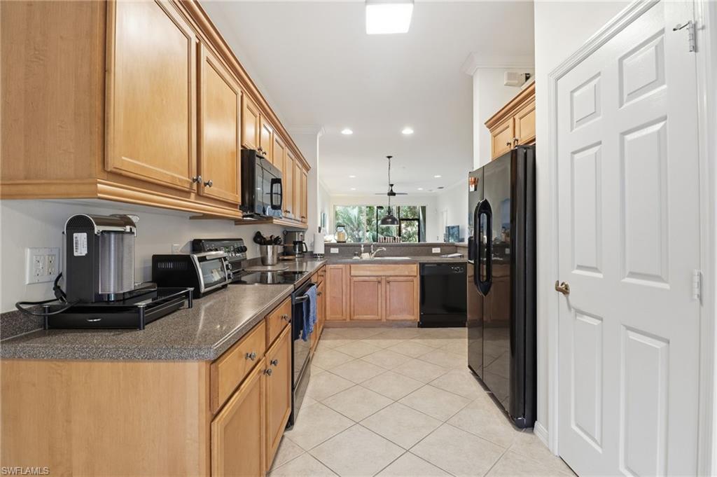 Kitchen featuring black appliances, pendant lighting, recessed lighting, light tile patterned floors, and a peninsula