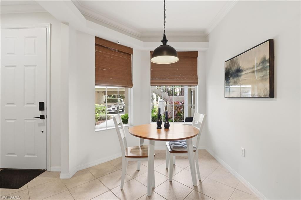 Dining room with ornamental molding and light tile patterned flooring