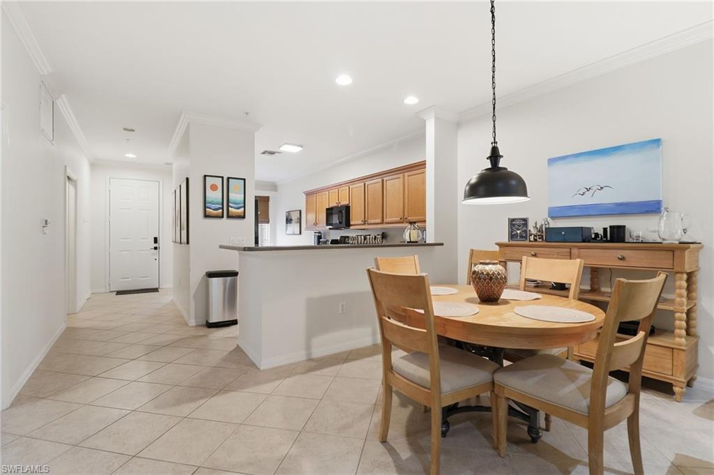Dining space with ornamental molding, recessed lighting, and light tile patterned flooring