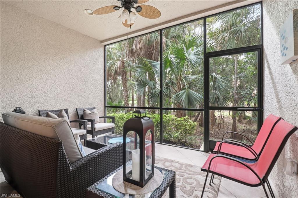 Sunroom with a textured wall, tile patterned flooring, a textured ceiling, and expansive windows