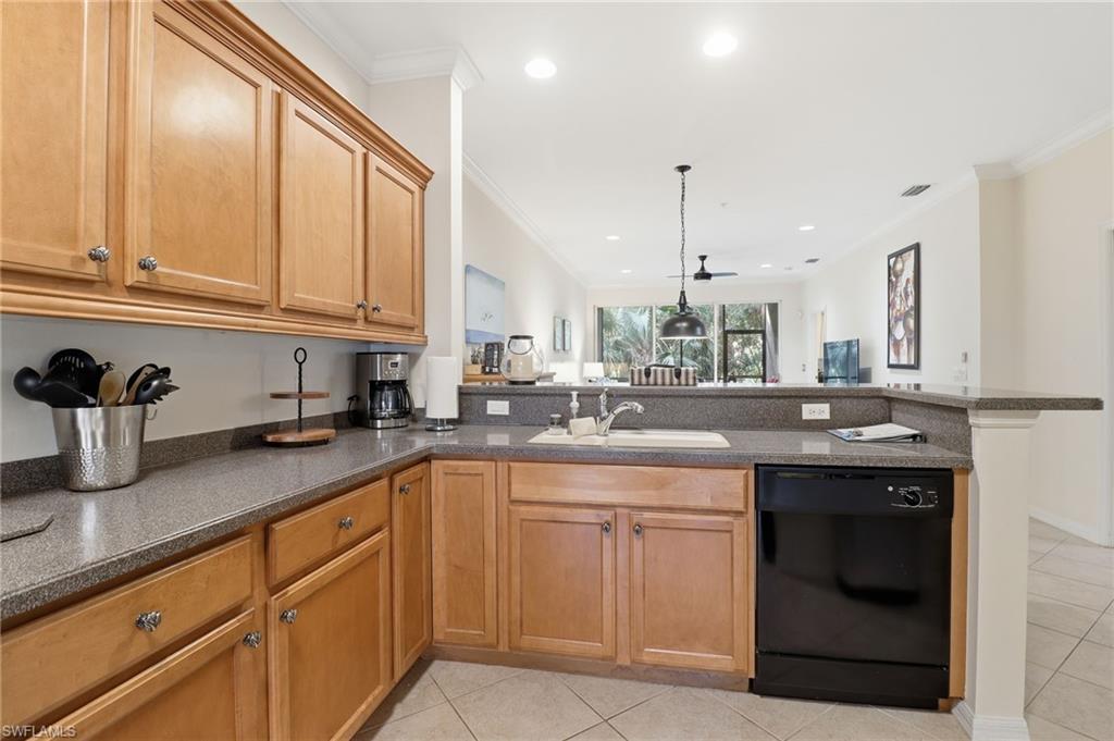 Kitchen with a peninsula, black dishwasher, crown molding, light tile patterned flooring, and brown cabinets