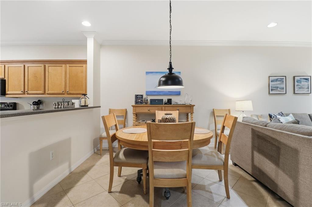 Dining area with ornamental molding, light tile patterned flooring, and recessed lighting
