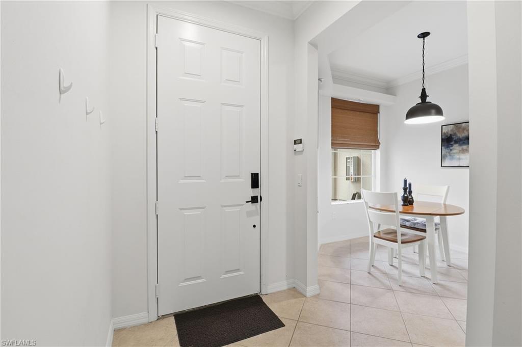 Foyer entrance featuring crown molding and light tile patterned floors