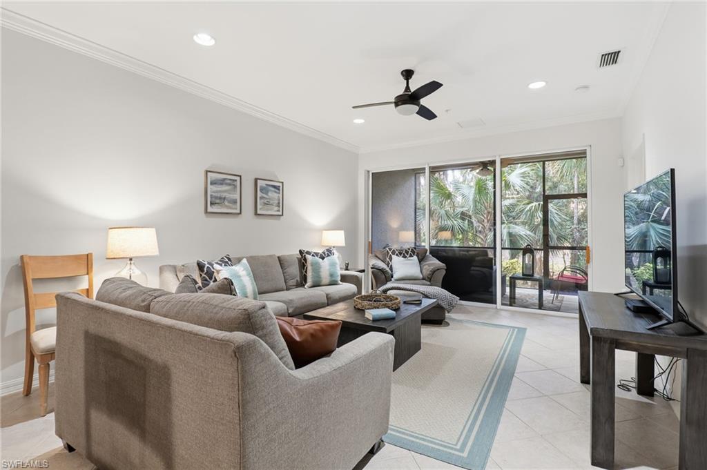 Living area with ornamental molding, recessed lighting, light tile patterned floors, and a ceiling fan
