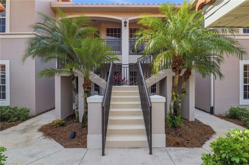 View of exterior entry featuring stucco siding and lush plants