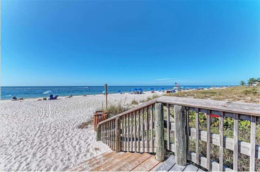 Direct beach access featuring a wooden walkway, white sand, and clear blue water