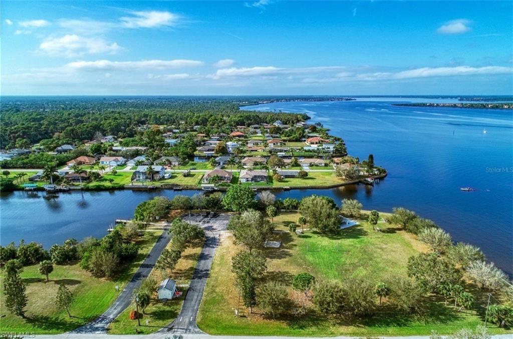 Expansive waterfront property featuring a large parcel of cleared land with two parallel driveways