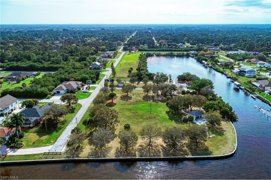 Expansive waterfront property featuring a canal, a lake, surrounding green spaces, mature trees, and a gazebo
