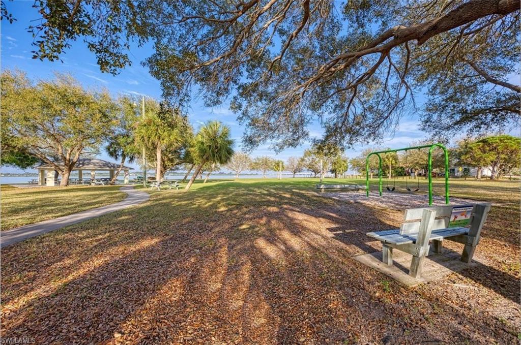 Expansive grassy area with mature trees providing natural shading