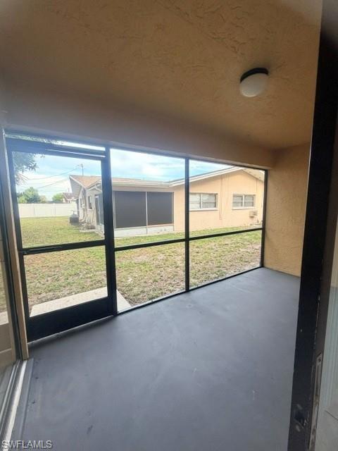 Screened patio with a smooth dark gray floor and textured tan ceiling