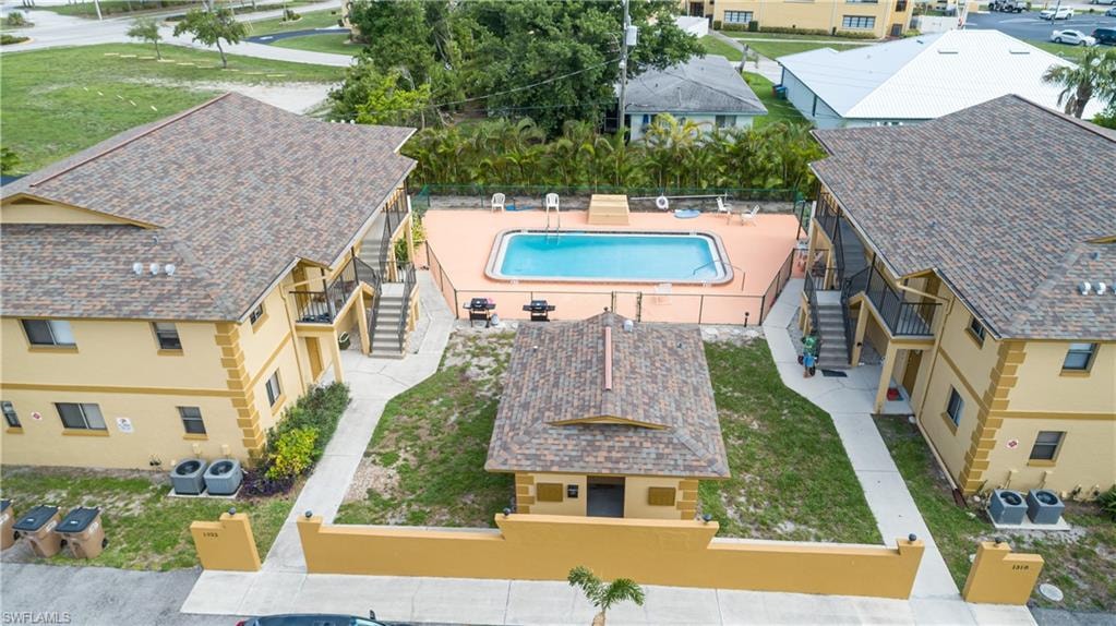 Centrally located swimming pool surrounded by a paved deck and privacy fencing