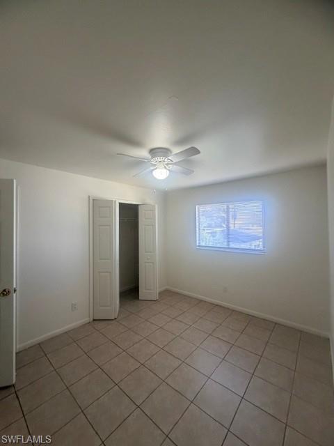 Bright interior space featuring tiled flooring, a window with blinds, and a ceiling fan