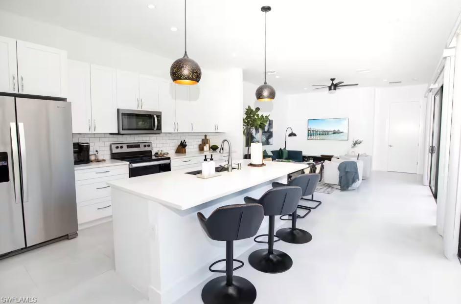 Bright open-concept kitchen, dining area, living room