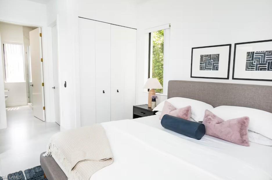 Master bedroom with a closet, and a master bathroom view