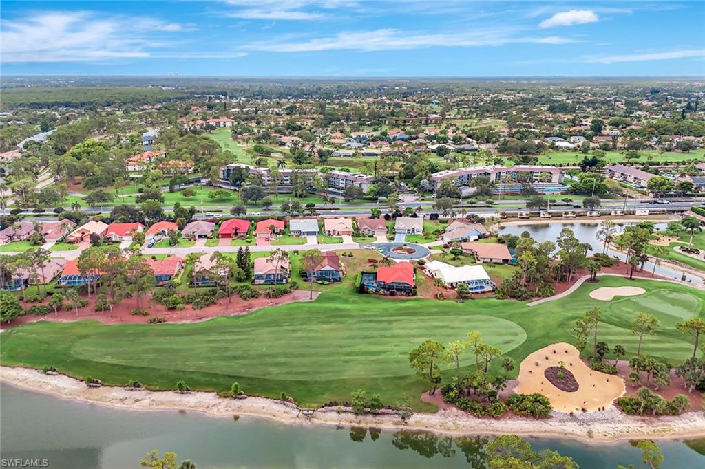 Aerial view of residential area featuring a large body of water and a local golf course