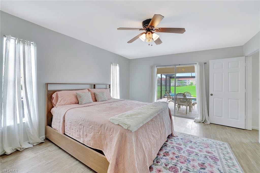 Bedroom featuring access to exterior, light wood-style floors, and ceiling fan