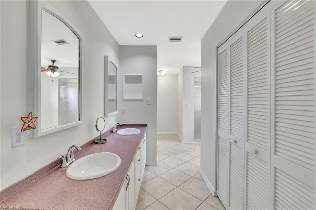 Full bathroom featuring a closet, double vanity, tile patterned floors, and a ceiling fan