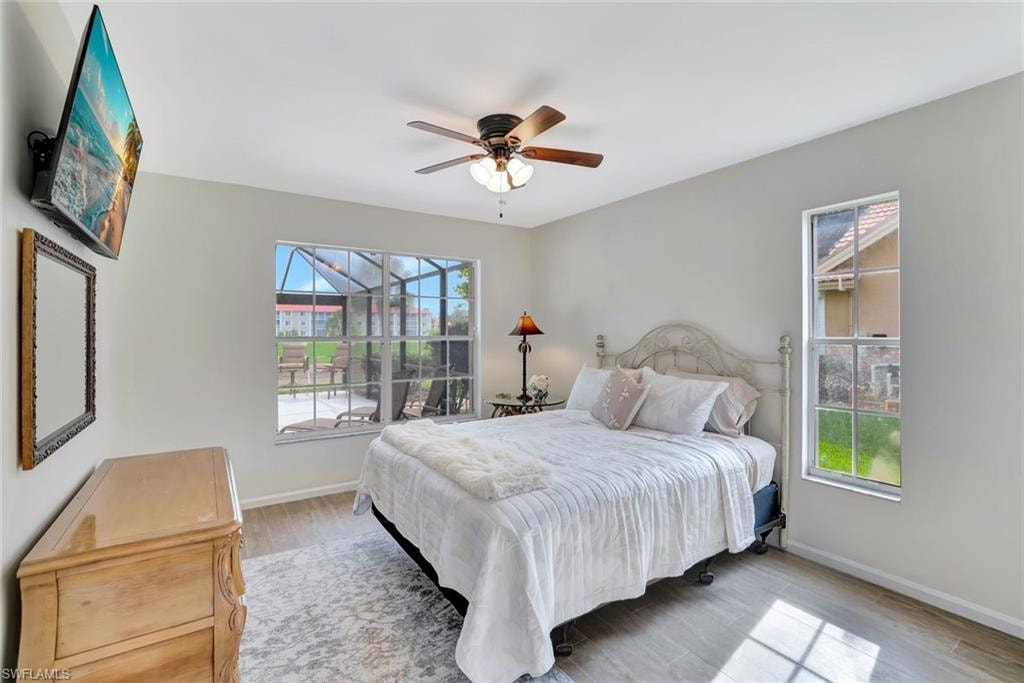 Bedroom with wood finished floors, baseboards, and a ceiling fan