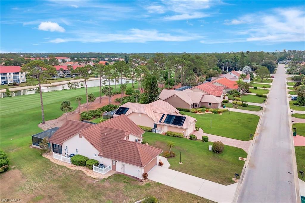 Aerial perspective of suburban area with a nearby body of water and a local golf course