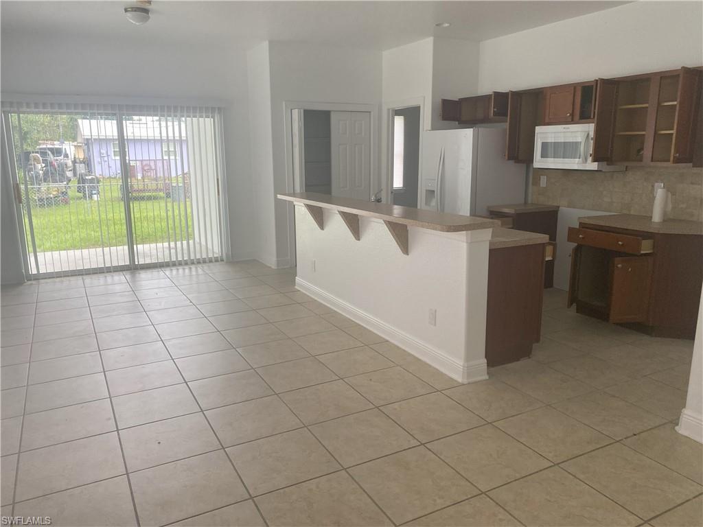 Open-concept living space featuring ceramic tile flooring and a kitchen island with an extended breakfast bar
