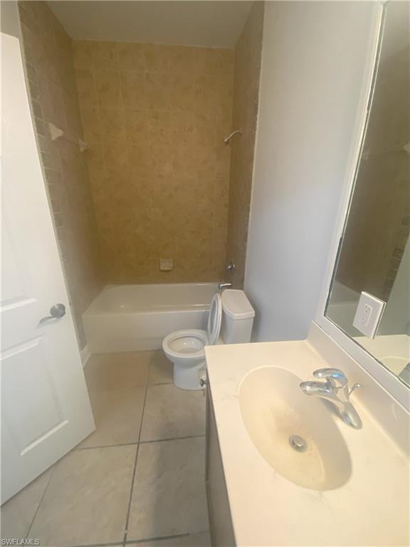 Bathroom featuring a white vanity with integrated sink, chrome faucet, and a large wall-mounted mirror