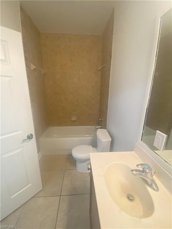 Bathroom featuring a white bathtub, ceramic wall tiling, and a toilet