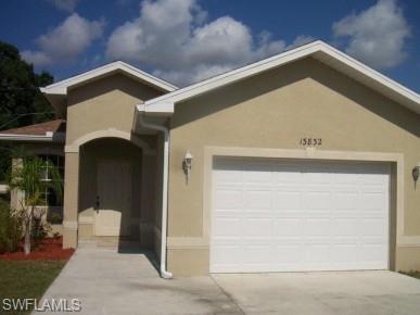 Stucco exterior with a peaked roofline and white trim