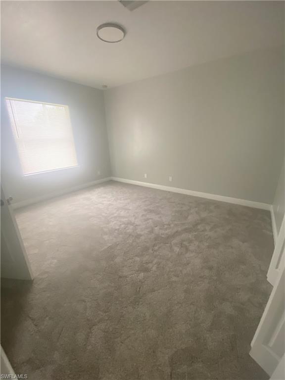 Room featuring neutral gray wall paint, light gray carpeting, and white baseboards