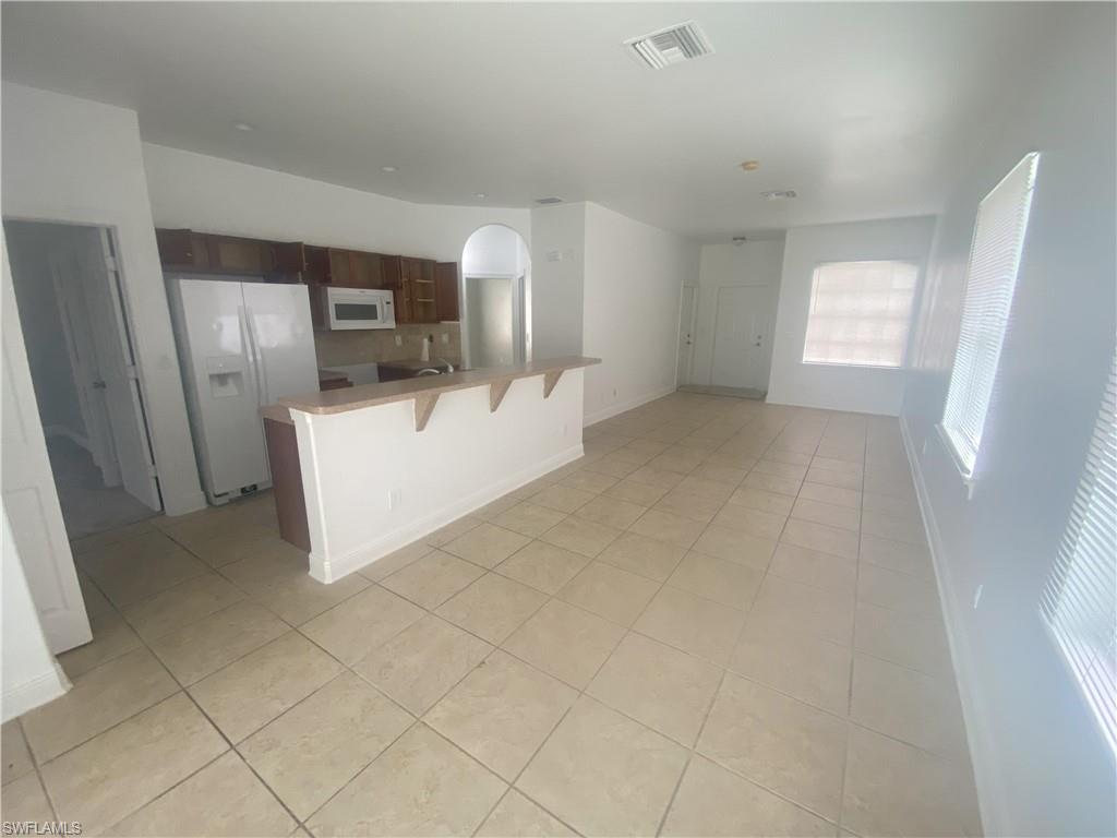 Open-concept living space featuring neutral tone tile flooring