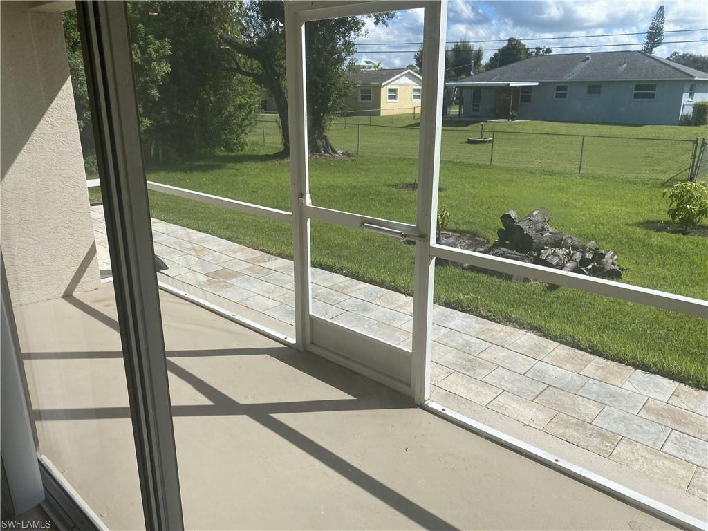 Screened patio featuring a concrete floor and a paver pathway