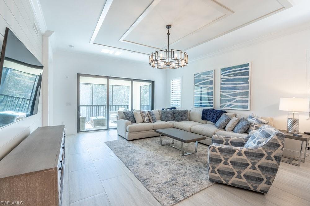 Living room featuring an inviting chandelier and ornamental molding