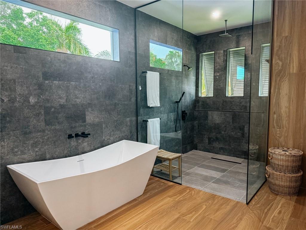 Freestanding soaking tub complemented by a spacious glass-enclosed shower