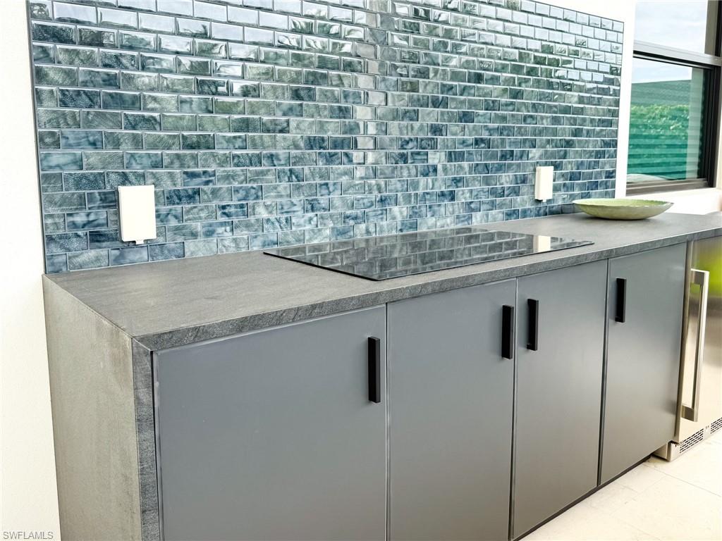 Outdoor Kitchen with Electric Cooktop and Dark Grey Storage Cabinets, Mosaic Tile Backsplash
