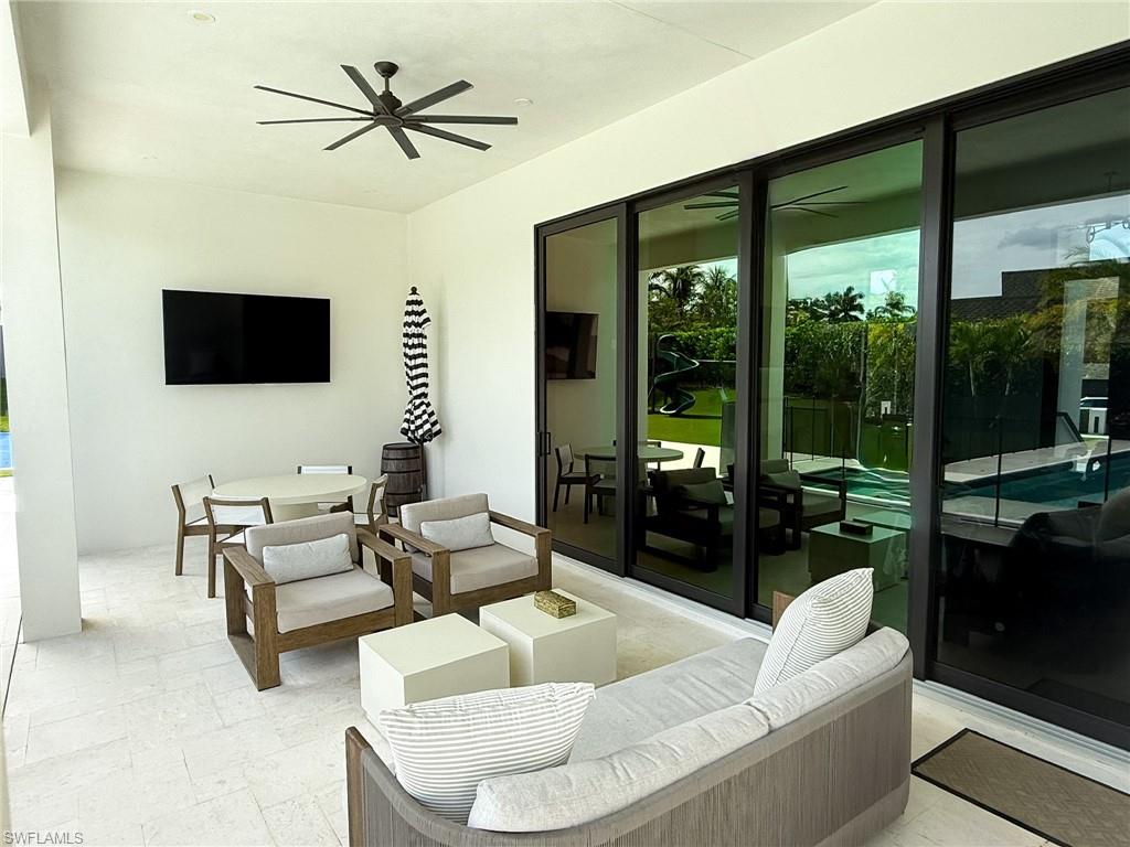 Covered patio featuring a ceiling fan and integrated television