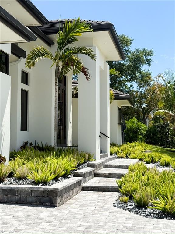 Contemporary exterior with a prominent entry, dual dark-framed glass doors, and a paver walkway