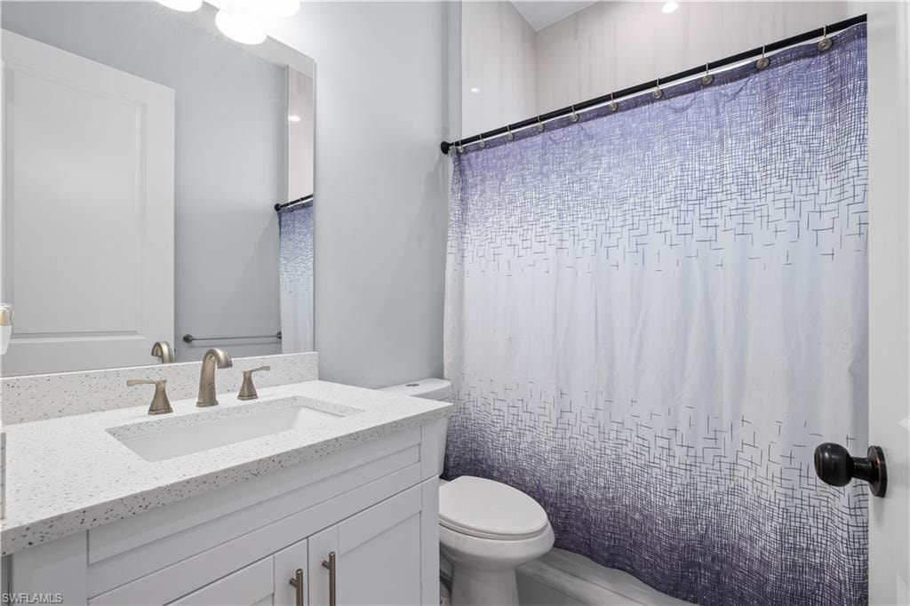 Bathroom featuring a vanity with an integrated sink, a speckled countertop, and brushed nickel fixtures