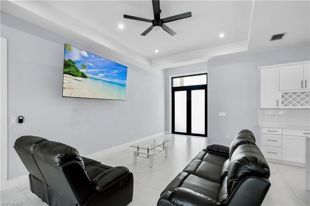 Open-concept living space featuring sleek tile flooring, recessed lighting, and a modern ceiling fan