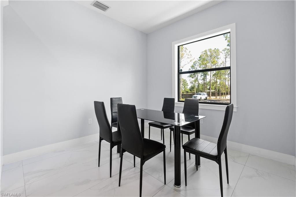 Bright interior space featuring light-toned walls and large format tile flooring