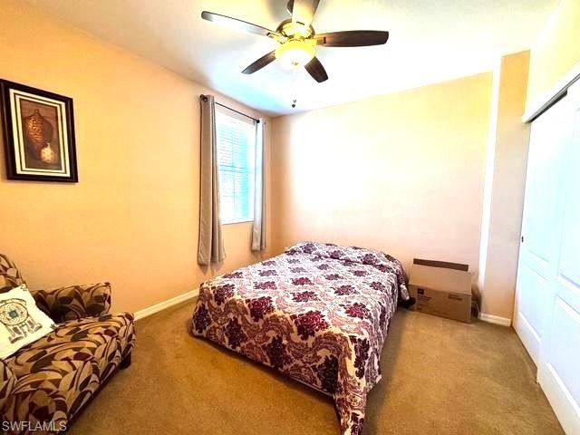 Bedroom featuring ceiling fan, a closet, and carpet