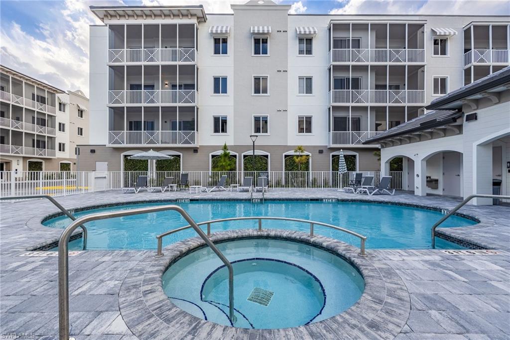 Pool featuring a community hot tub and fence