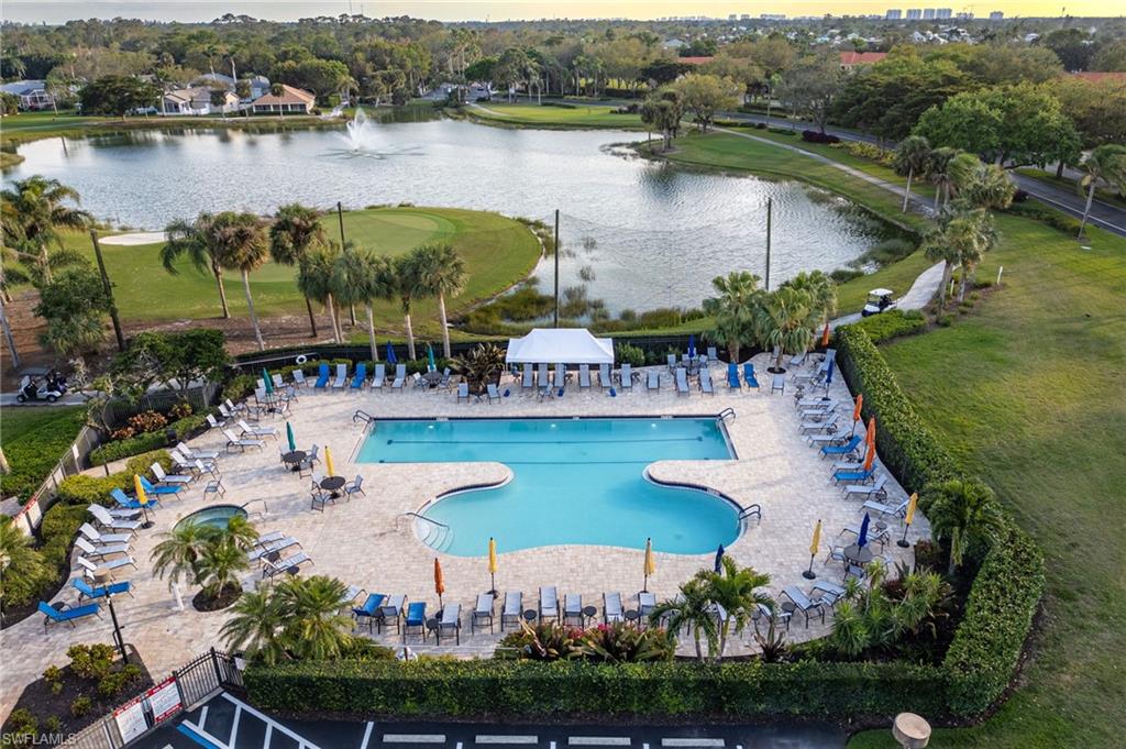 Pool with a water view, fence, and a patio