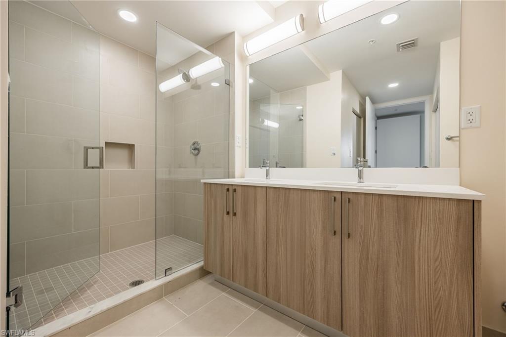 Full bathroom with a shower stall, visible vents, tile patterned floors, and a sink
