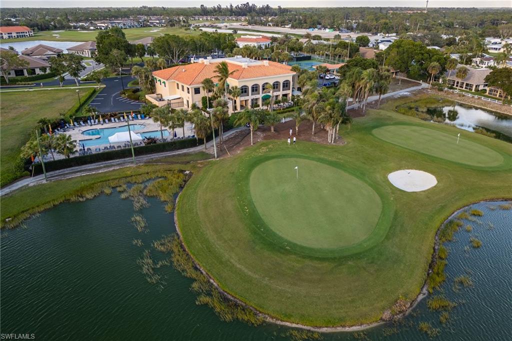 Birds eye view of property with golf course view and a water view
