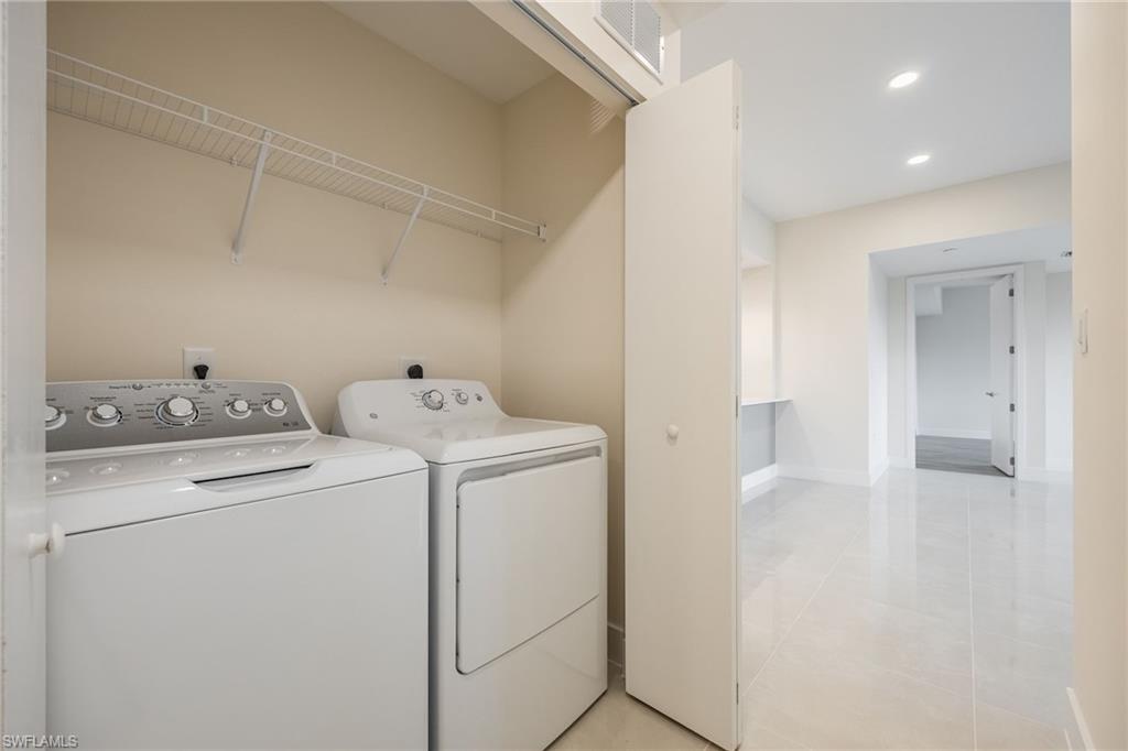 Laundry area with laundry area, washing machine and dryer, baseboards, visible vents, and recessed lighting